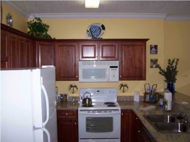 10519 Front Beach Road, Unit 2201 Panama City Beach, FL 32408 - Photo 3 of 10 a kitchen with stainless steel appliances granite countertop a stove a refrigerator and a stove