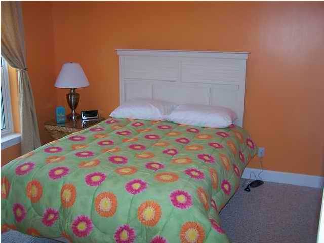 10519 Front Beach Road, Unit 2201 Panama City Beach, FL 32408 - Photo 5 of 10 a bedroom with a bed and a chair