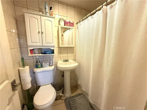 a bathroom with a sink a toilet and shower curtain
