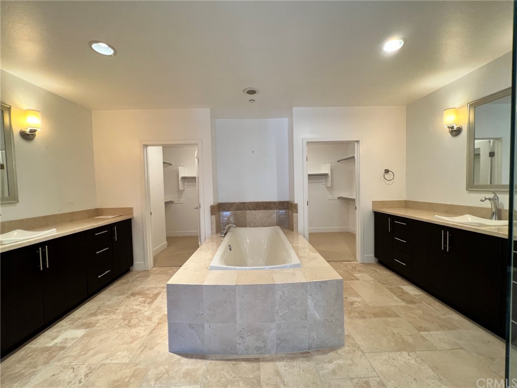 402 Rockefeller, Unit 212 Irvine, CA 92612 - Photo 16 of 27 a large bathroom with a tub sink vanity granite and a mirror