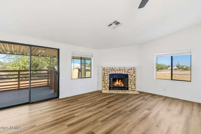 wooden floor fireplace and windows in an empty room