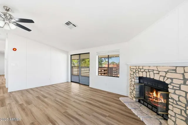 a view of empty room with a fireplace and wooden floor