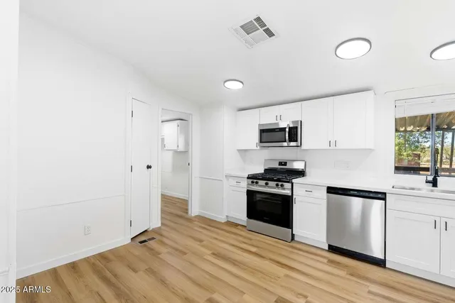 a kitchen with stainless steel appliances granite countertop a stove and a refrigerator
