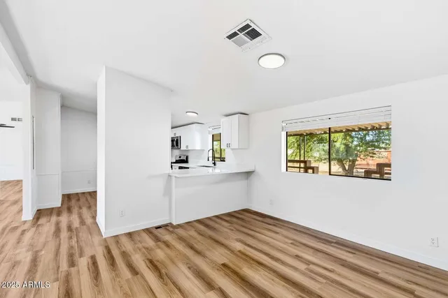 a view of a kitchen with wooden floor a sink and windows