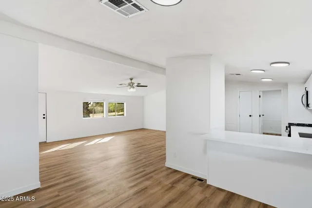 a view of a livingroom and a kitchen with wooden floor