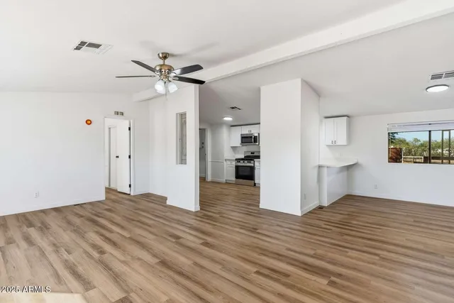 a view of a kitchen with wooden floor and a ceiling fan