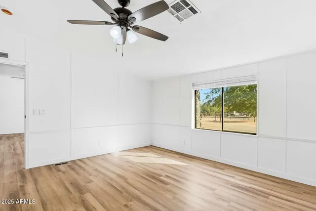an empty room with a window and a ceiling fan