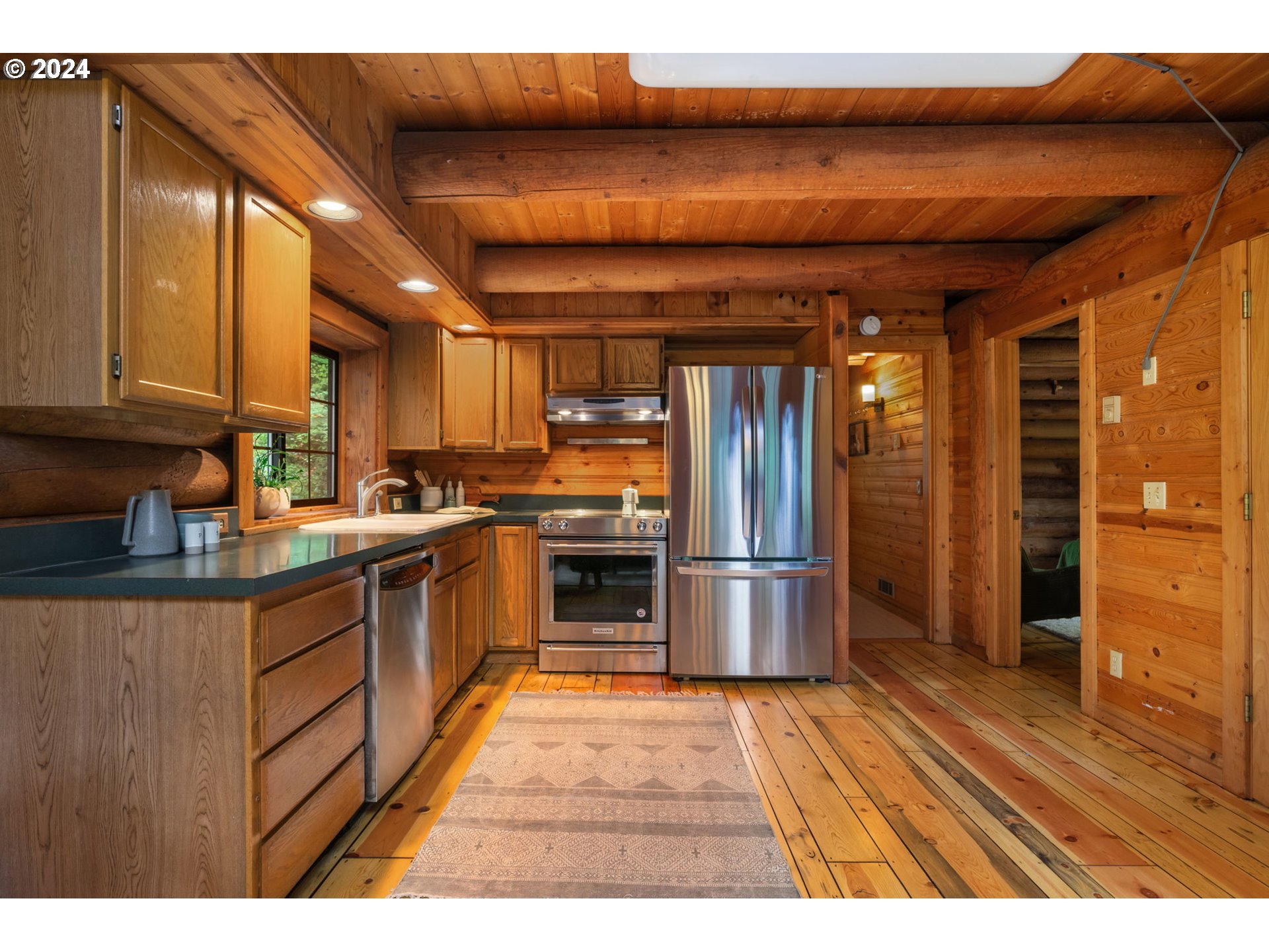 24271 South Newkirchner Road Oregon City, OR 97045 - Photo 12 of 41 a kitchen with stainless steel appliances granite countertop a refrigerator a sink dishwasher and wooden cabinets with wooden floor