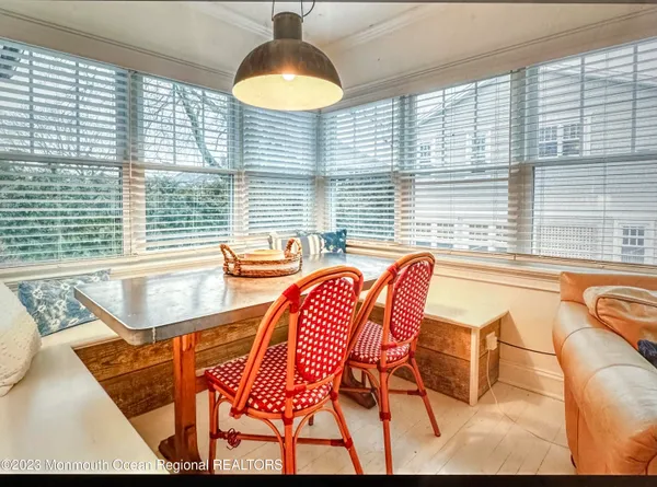 a dining room with furniture and a large window