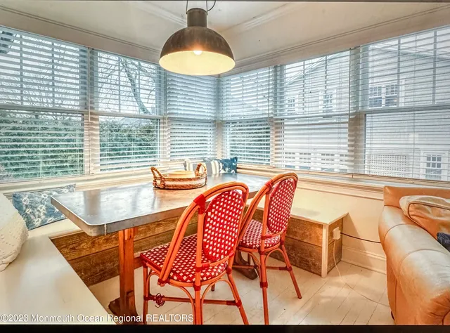 a dining room with furniture and a large window