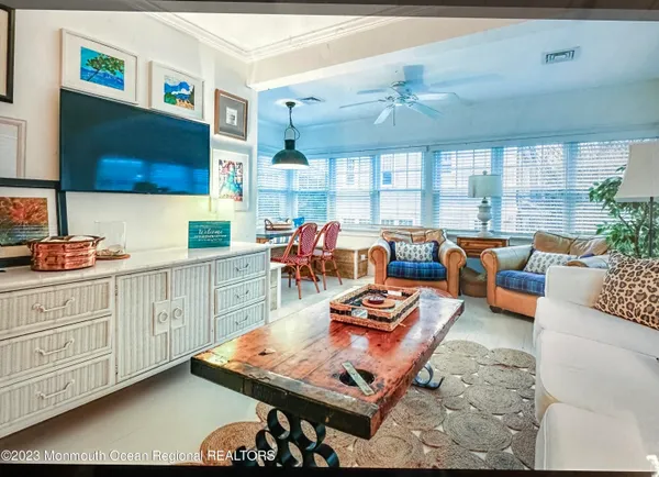a living room with furniture a flat screen tv and a large window