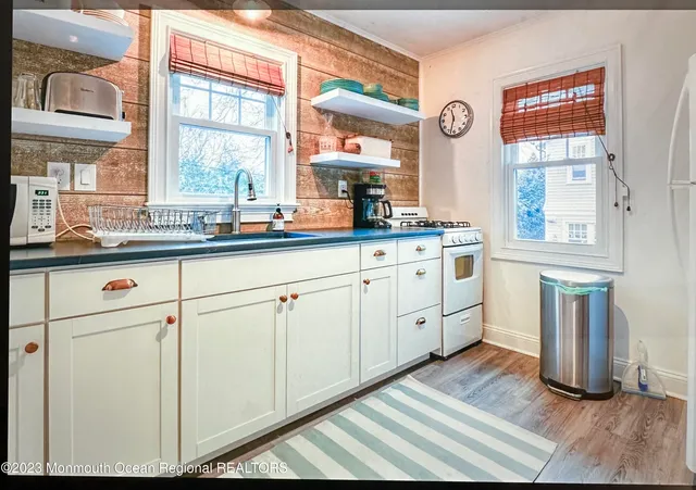 a kitchen with white cabinets and a window