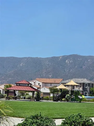 a view of big green field in front of house with yard
