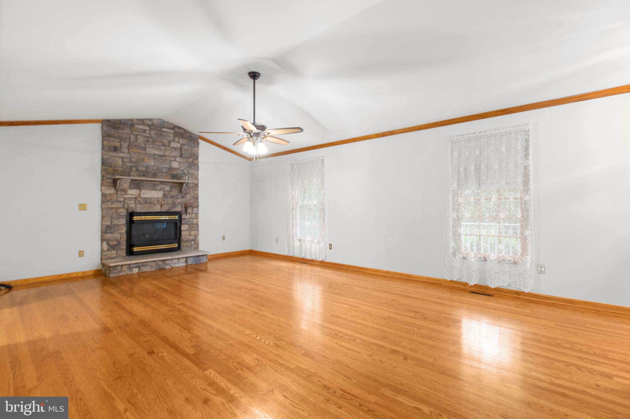 6628 Courthouse Road Spotsylvania, VA 22551 - Photo 9 of 45 an empty room with wooden floor fireplace and chandelier