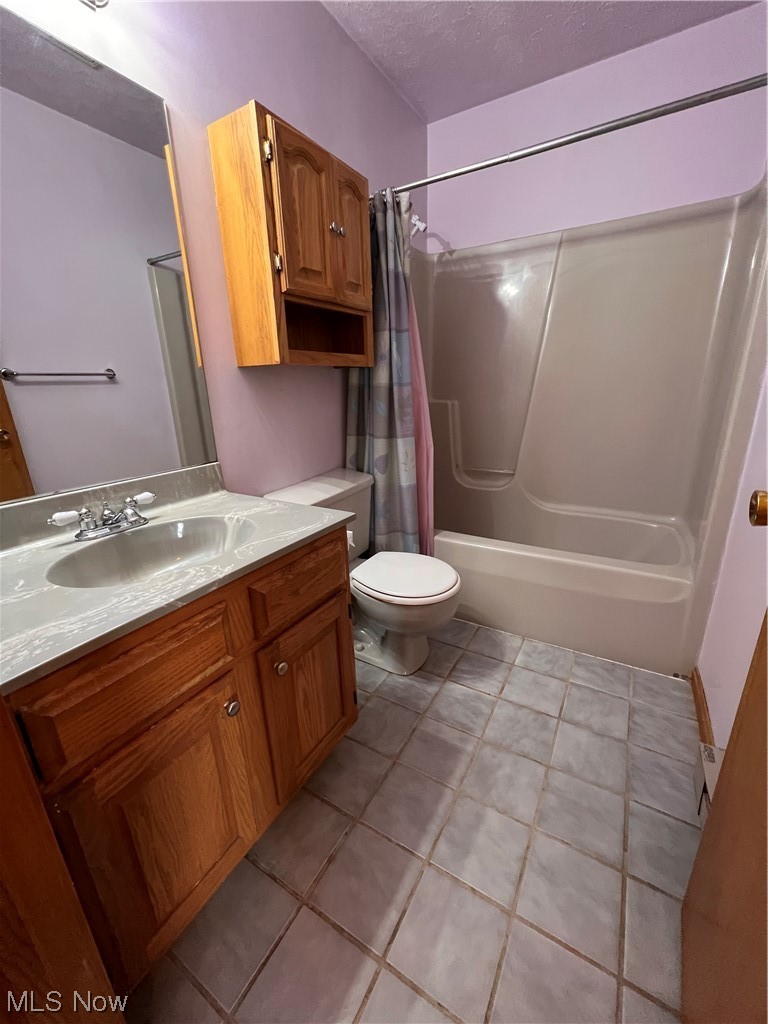 5435 Columbia Road Medina, OH 44256 - Photo 15 of 30 Full bathroom with shower / tub combo with curtain, a textured ceiling, tile flooring, toilet, and vanity with extensive cabinet space