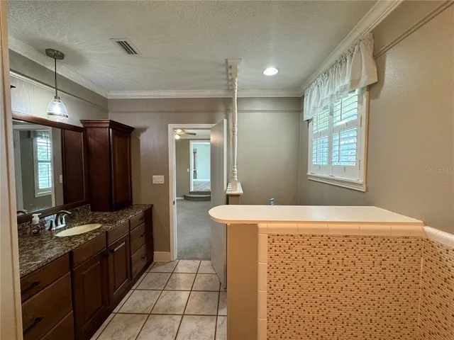 a spacious bathroom with a double vanity sink a mirror and a bathtub