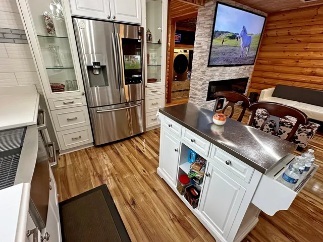 a view of a kitchen with fridge and wooden floor