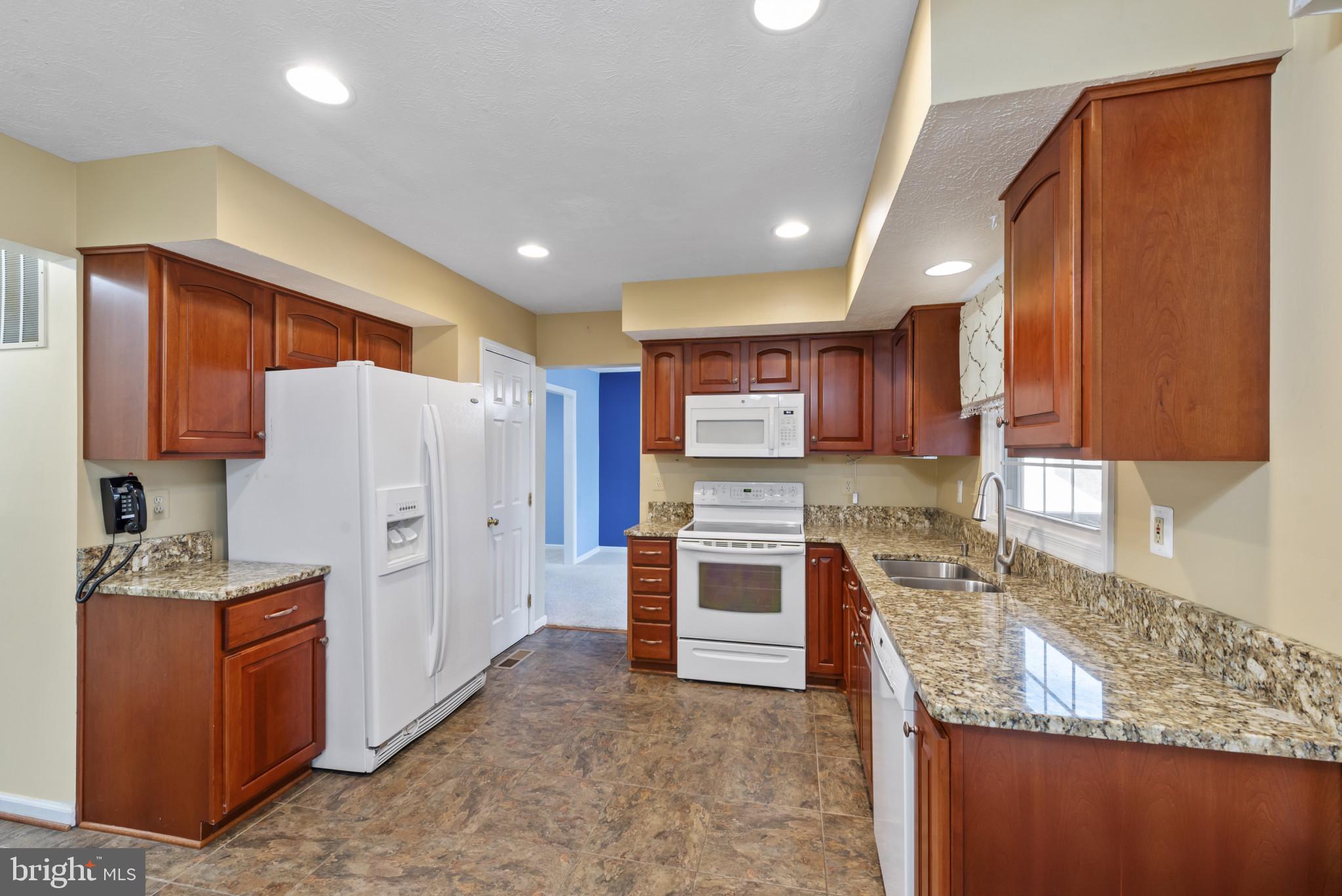 452 Doe Meadow Drive Owings Mills, MD 21117 - Photo 4 of 34 a kitchen with stainless steel appliances granite countertop a refrigerator sink and stove