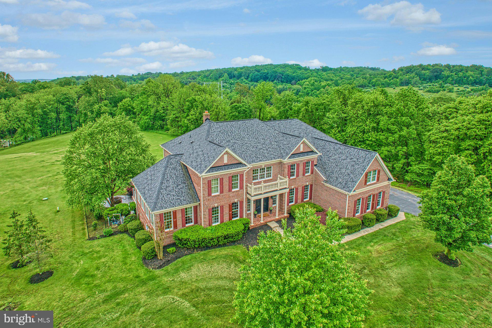 a aerial view of a house next to a big yard and large trees