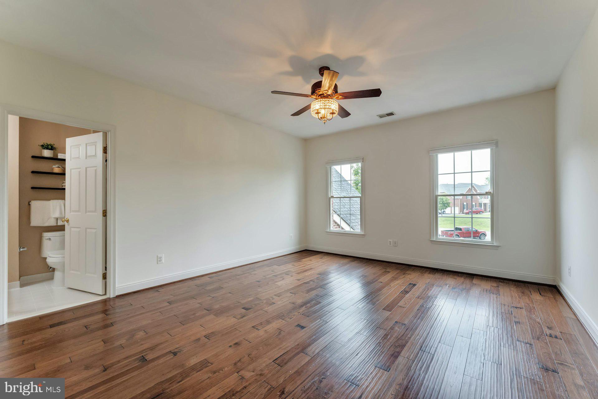 18102 Eaglesham Court Leesburg, VA 20175 - Photo 45 of 92 an empty room with wooden floor chandelier fan and windows