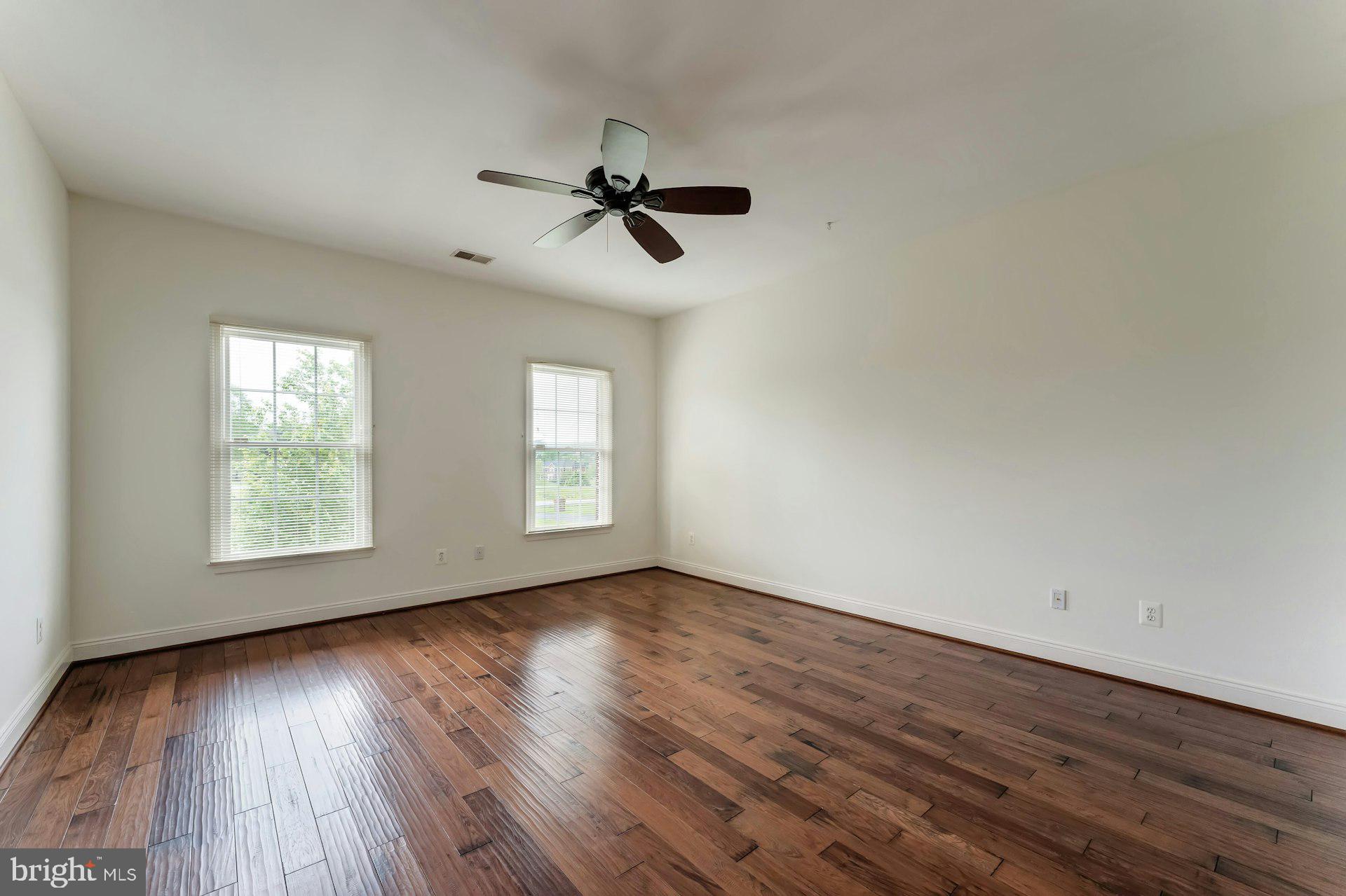 18102 Eaglesham Court Leesburg, VA 20175 - Photo 49 of 92 an empty room with wooden floor fan and windows