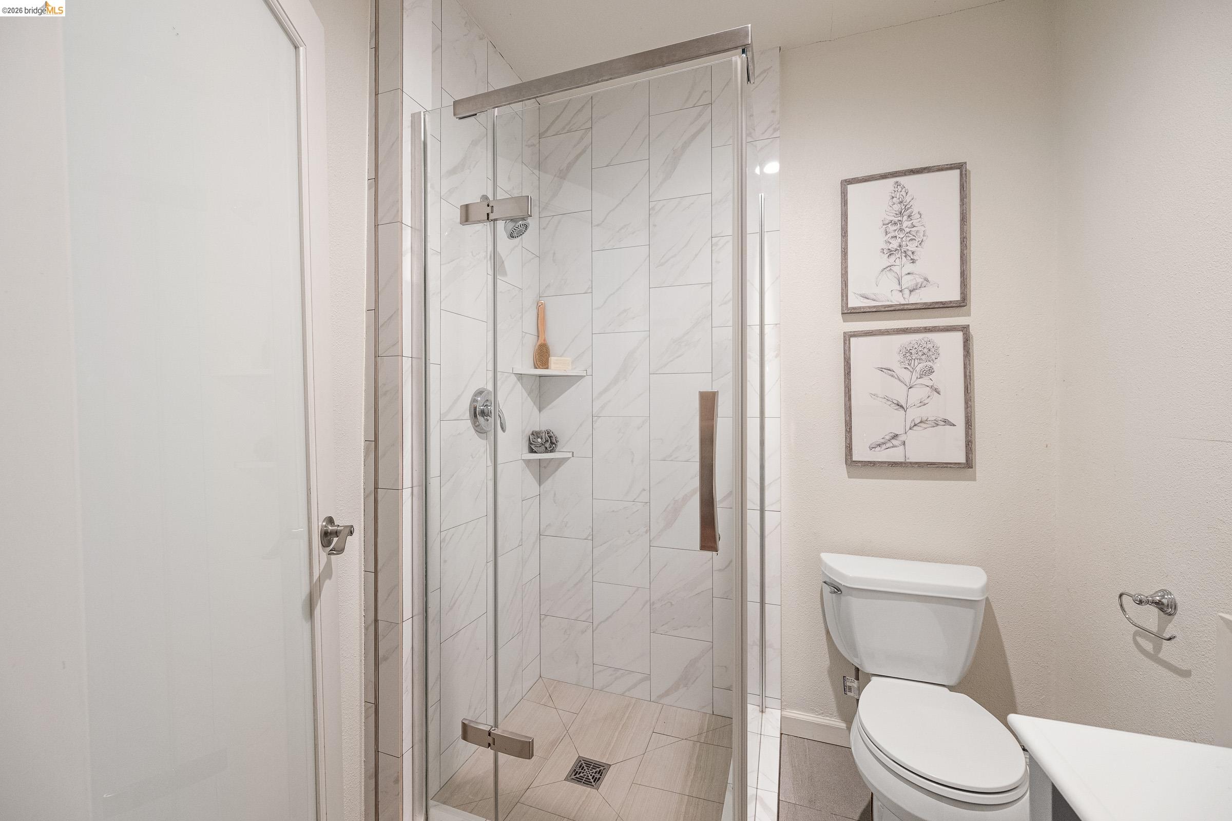 6600 Heather Ridge Way Oakland, CA 94611 - Photo 54 of 66 Frameless glass shower enclosure with white tile surround and integrated corner shelving