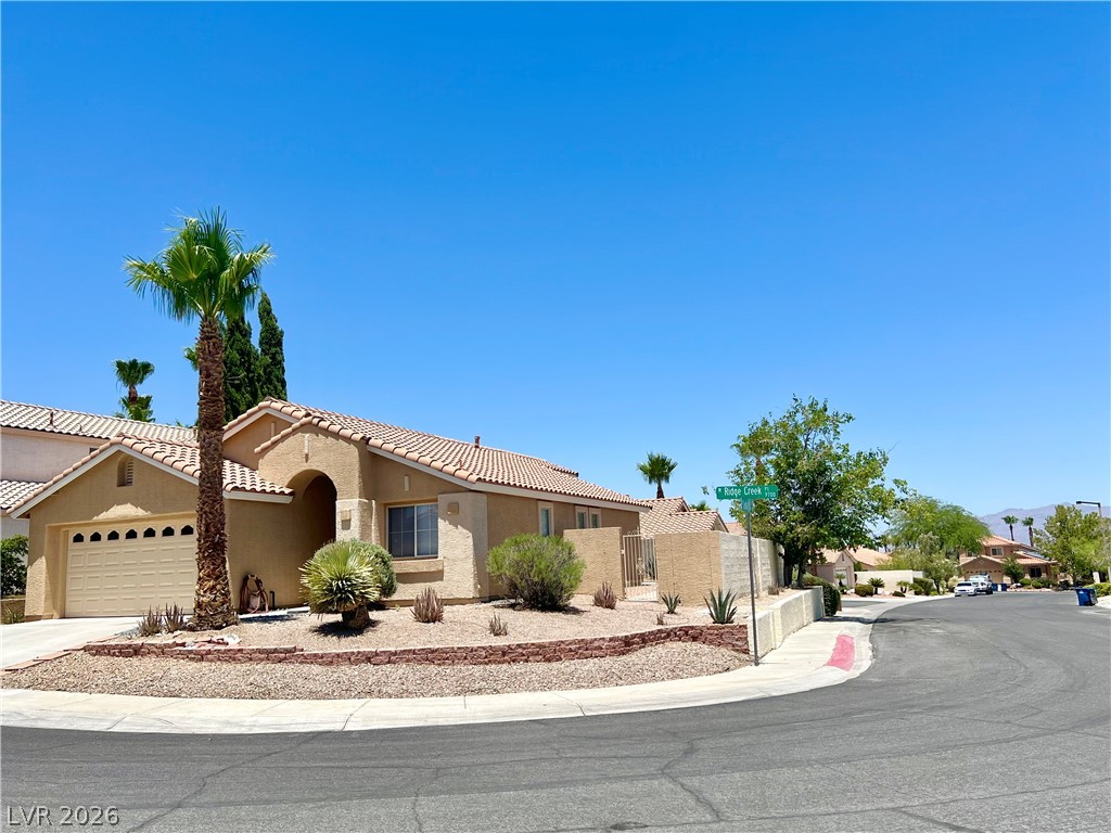 9708 Ridge Creek Place Las Vegas, NV 89134 - Photo 7 of 43 A desert-friendly landscape surrounds this charming single-level residence with an attached garage.