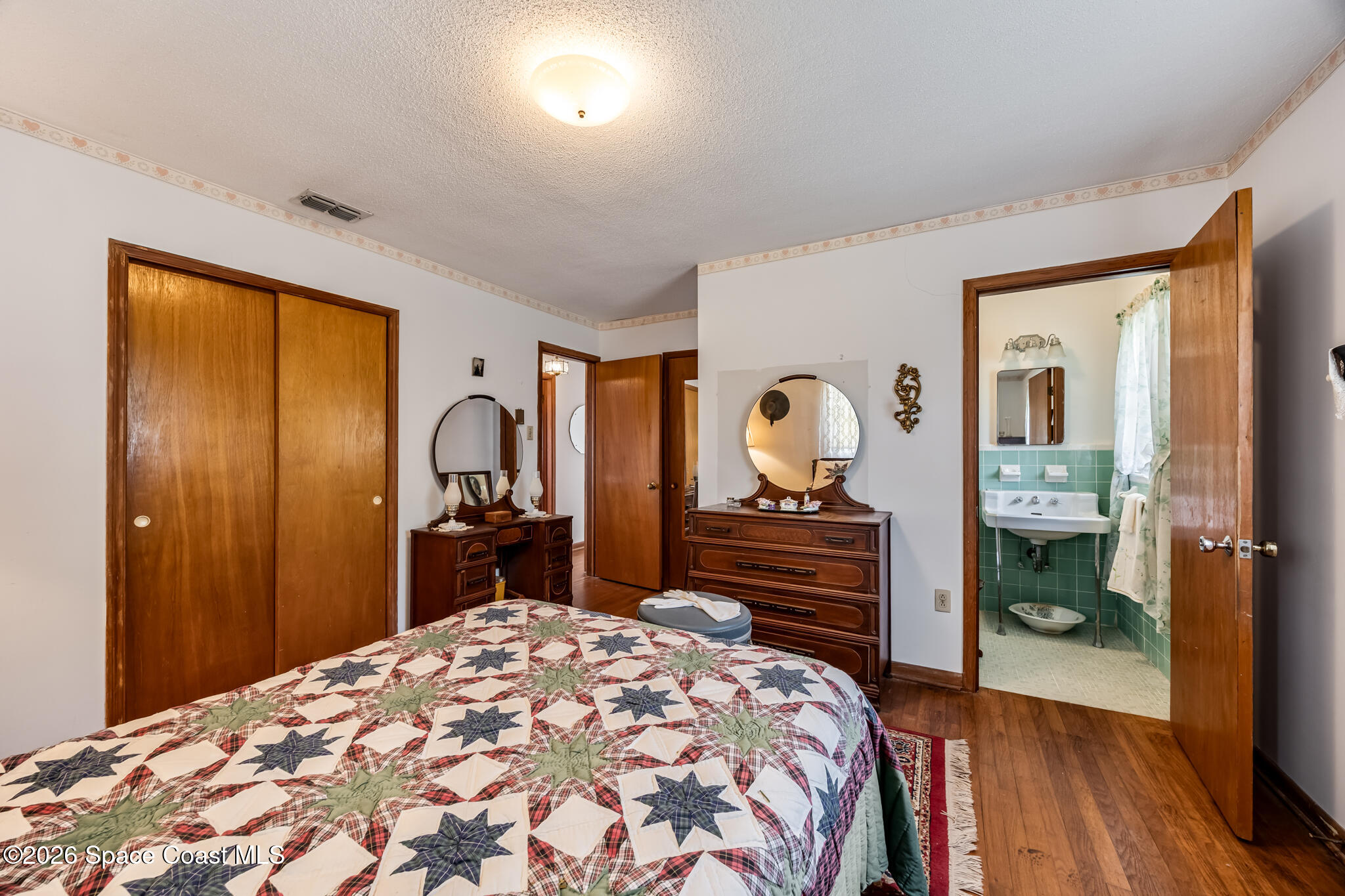 2030 City Acres Road Melbourne, FL 32904 - Photo 10 of 31 a bedroom with a bed and a dresser with mirror
