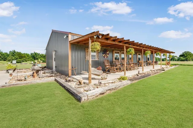 a view of a house with a big yard and sitting area