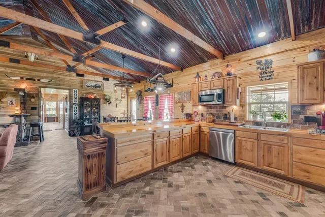 a large kitchen with lots of counter space dining table and stainless steel appliances