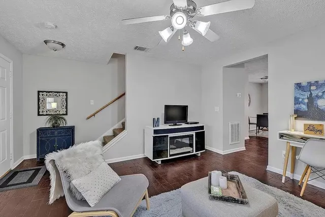 a living room with furniture and a wooden floor
