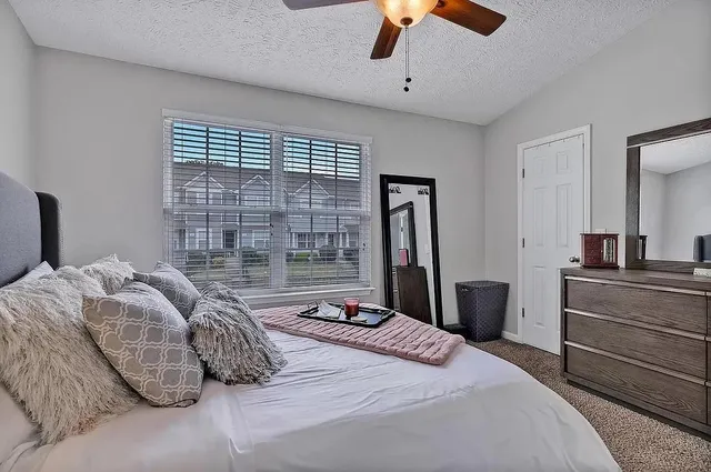 a bedroom with a large bed and a chandelier