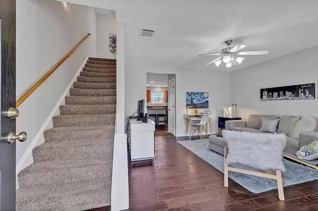 a living room with furniture and wooden floor