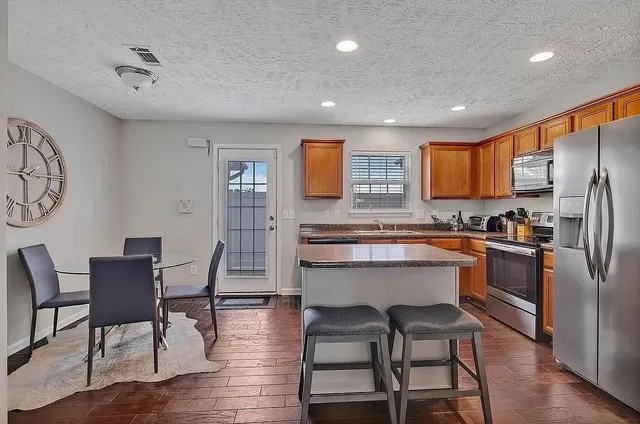 a kitchen with a table chairs refrigerator and cabinets