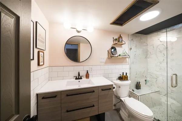 a bathroom with a toilet a sink and mirror