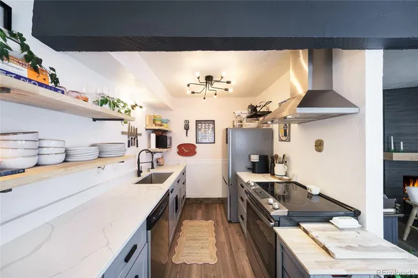 a kitchen with stainless steel appliances a stove a sink and a refrigerator