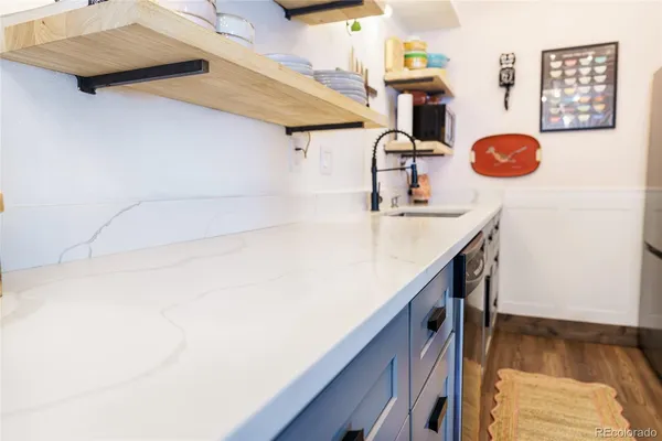 a kitchen with a sink and a stove with wooden floor