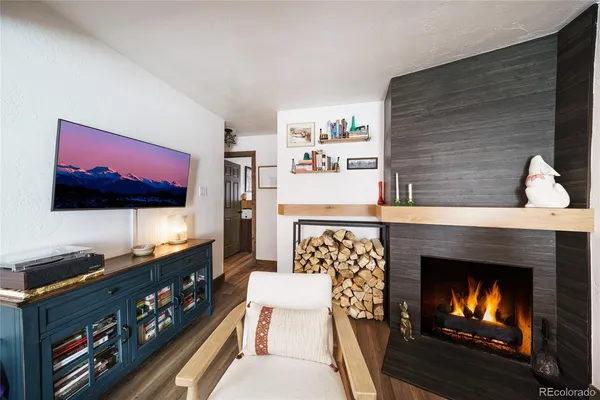 a living room with furniture a flat screen tv and a fireplace