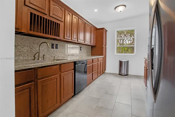 a kitchen with stainless steel appliances granite countertop a refrigerator and a sink