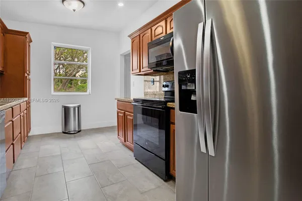 a kitchen with stainless steel appliances granite countertop a refrigerator and a stove