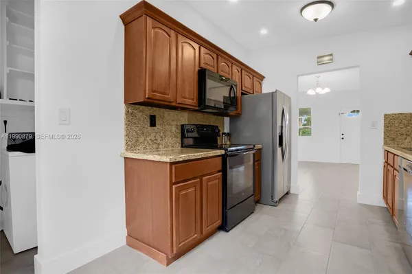 a kitchen with stainless steel appliances granite countertop a refrigerator and a stove