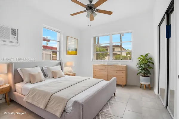 a bedroom with a bed a couch and a potted plant