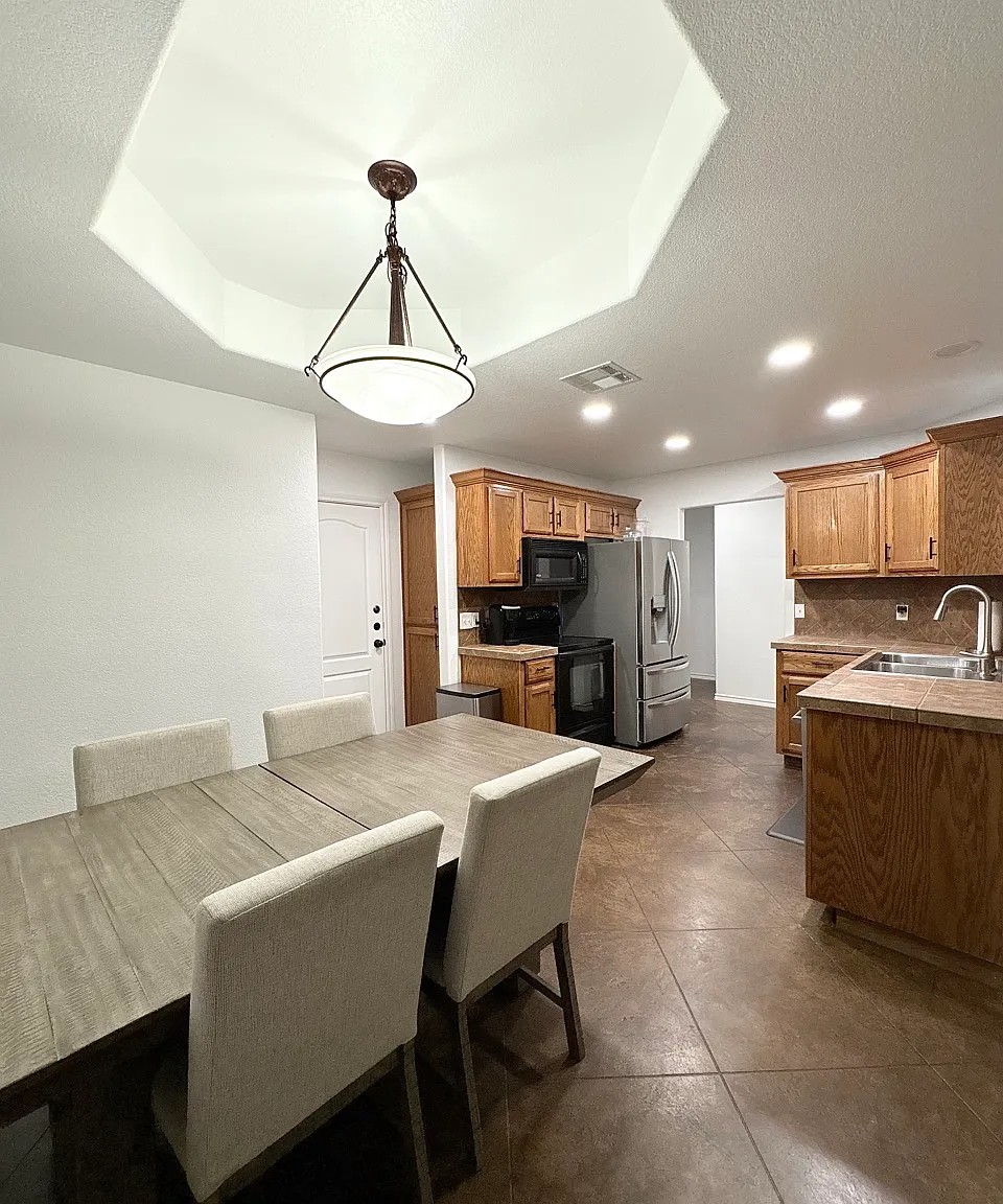 430 Summit Ridge Drive North Point Venture, TX 78645 - Photo 5 of 26 An inviting kitchen and dining area features ample wood cabinetry and modern appliances, perfect for daily living.