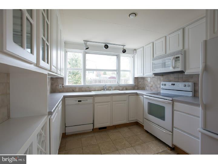 35 Beulah Road Doylestown, PA 18901 - Photo 10 of 41 a kitchen with granite countertop white cabinets a sink a window and stainless steel appliances