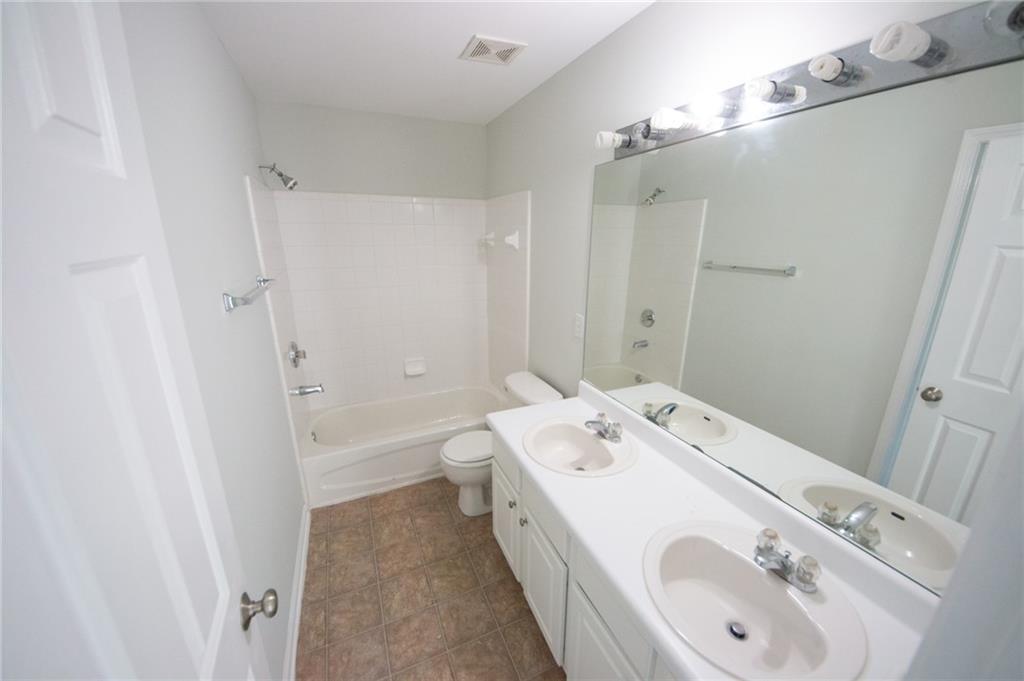 8145 Lockslay Way Suwanee, GA 30024 - Photo 13 of 18 a bathroom with a tub sink and mirror