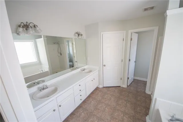 a bathroom with a double vanity sink and mirror with shower
