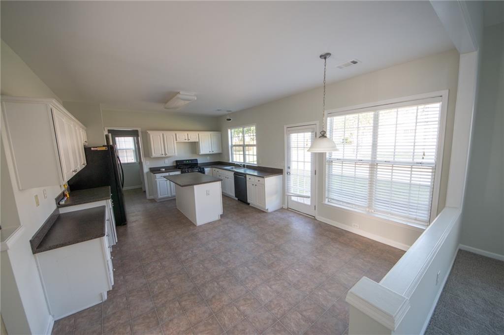 8145 Lockslay Way Suwanee, GA 30024 - Photo 2 of 18 a kitchen with stainless steel appliances granite countertop a refrigerator and a sink