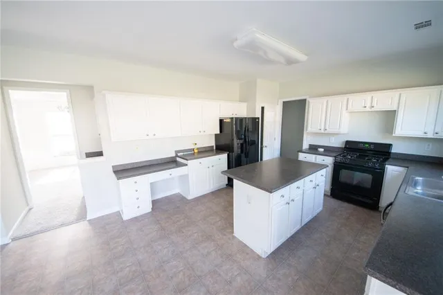 a kitchen with a refrigerator a stove a sink and a microwave