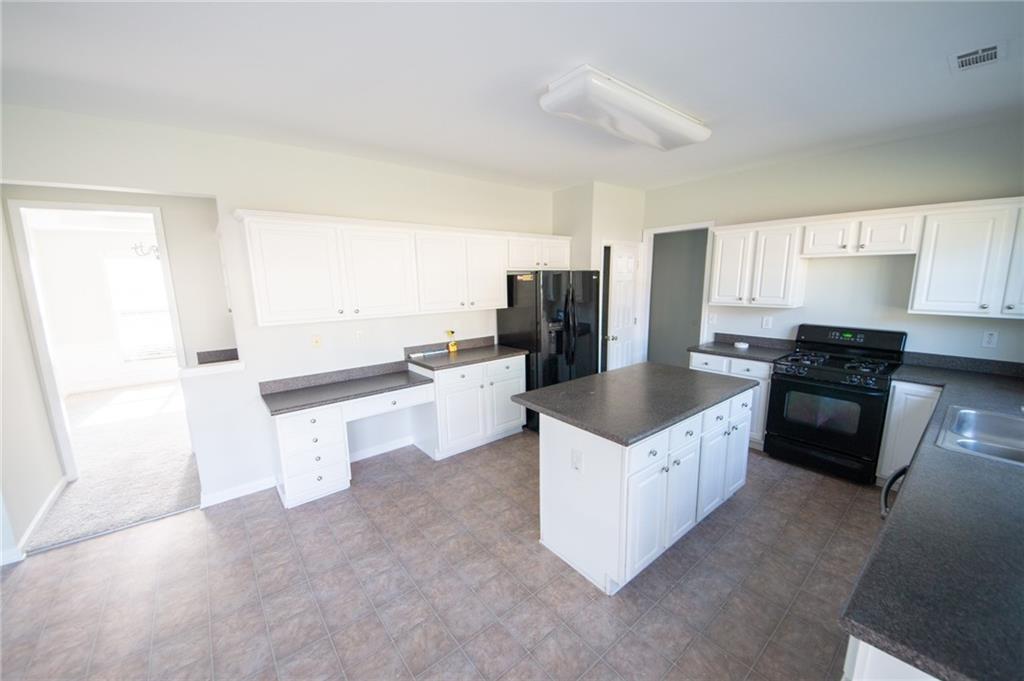 8145 Lockslay Way Suwanee, GA 30024 - Photo 5 of 18 a kitchen with a refrigerator a stove a sink and a microwave