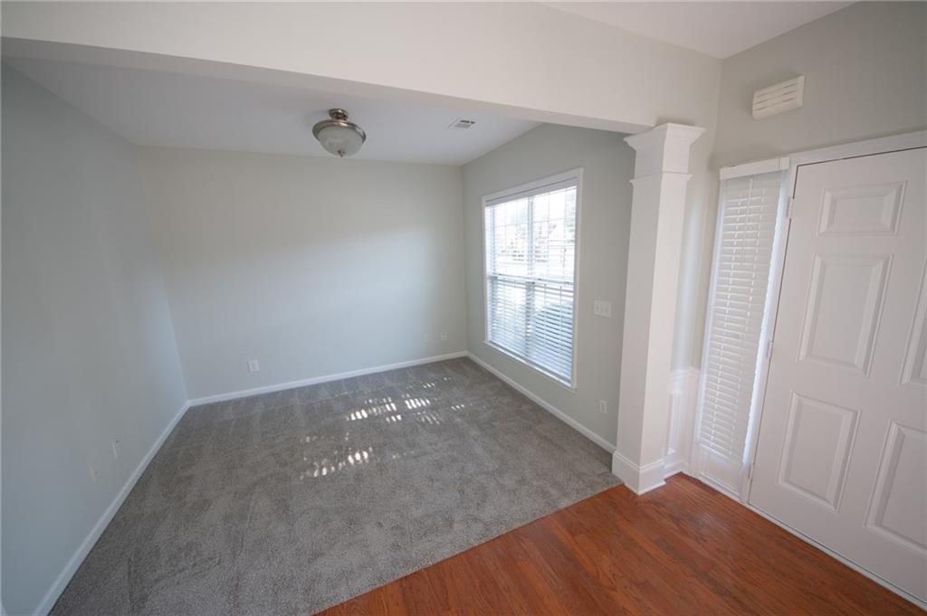 8145 Lockslay Way Suwanee, GA 30024 - Photo 8 of 18 an empty room with wooden floor and windows